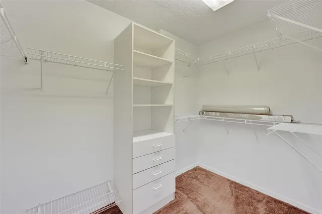 a view of a hallway with wooden floor and cabinet