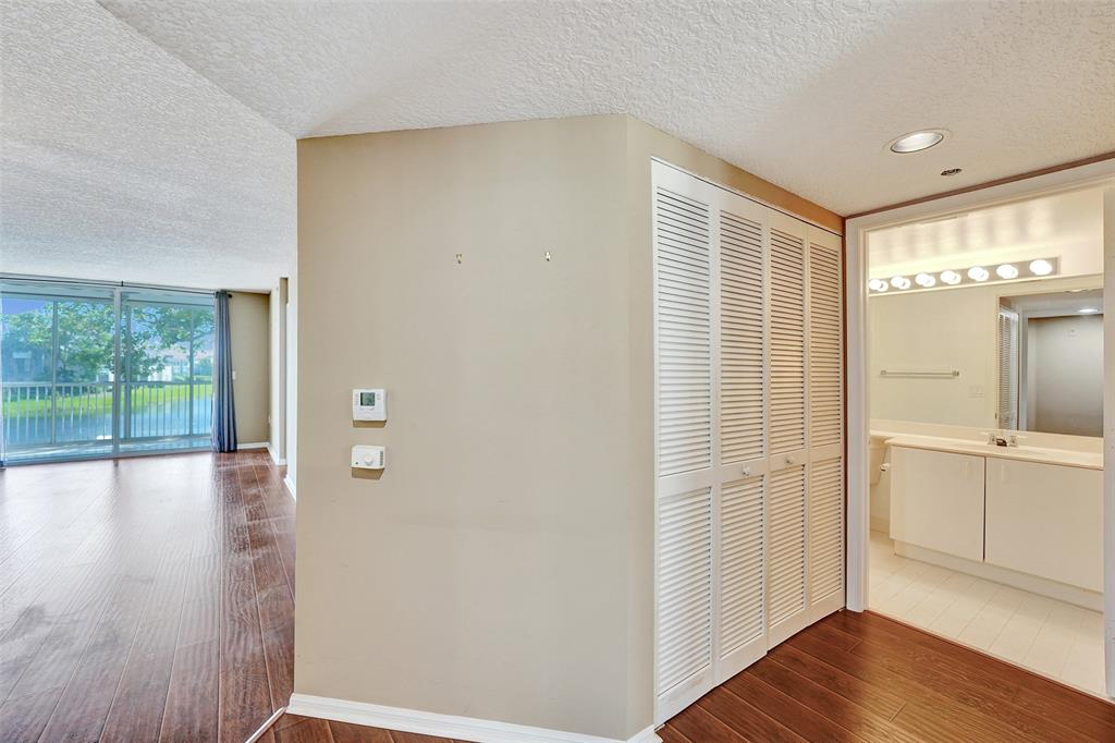 9563 Weldon Circle, Unit D212 Tamarac, FL 33321 - Photo 44 of 69 a view of a hallway with wooden floor and cabinet