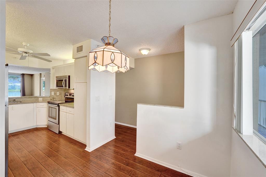 9563 Weldon Circle, Unit D212 Tamarac, FL 33321 - Photo 7 of 69 a kitchen with a refrigerator a stove cabinets and wooden floor