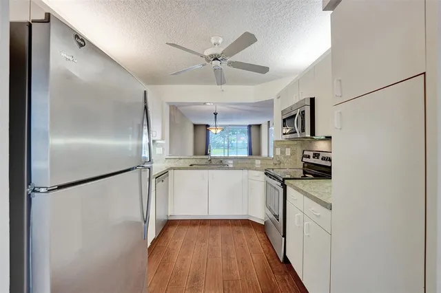 a kitchen with granite countertop a sink and steel appliances