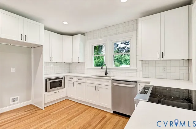 a kitchen with granite countertop white cabinets and white appliances