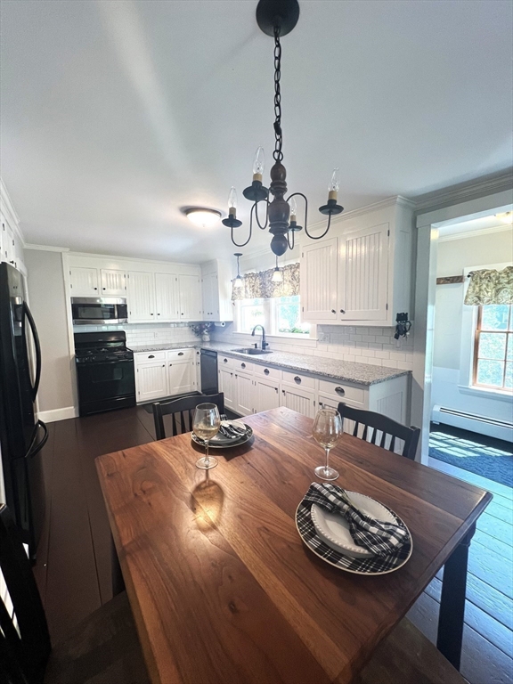 9 Newton Junction Road Kingston, NH 03848 - Photo 13 of 40 a kitchen with stainless steel appliances kitchen island granite countertop a stove a refrigerator a sink a dining table and chairs with wooden floor