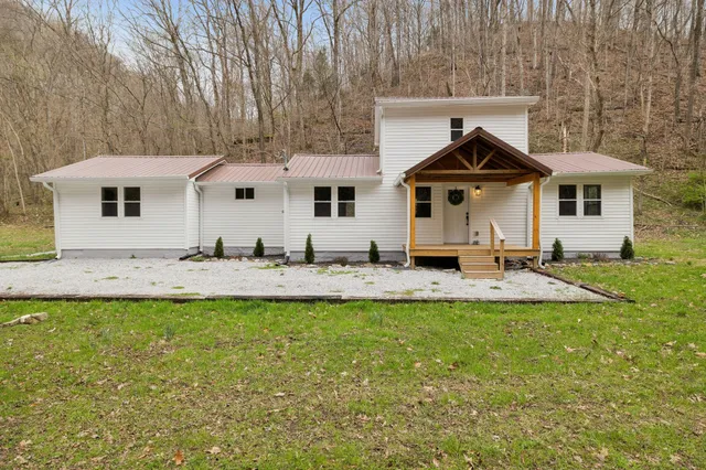 a front view of a house with a yard and seating space
