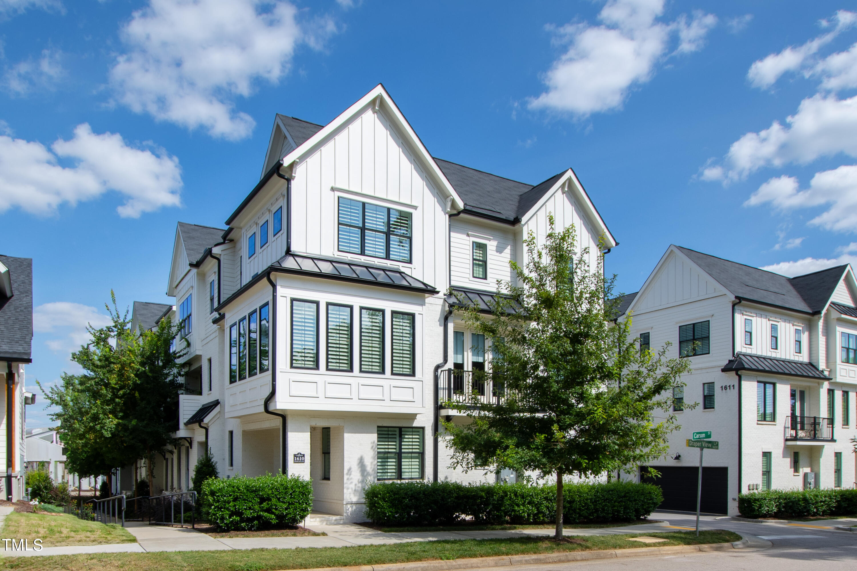 1610 Draper View Loop, Unit 106 Raleigh, NC 27608 - Photo 1 of 36 a view of a white building among the street and palm trees