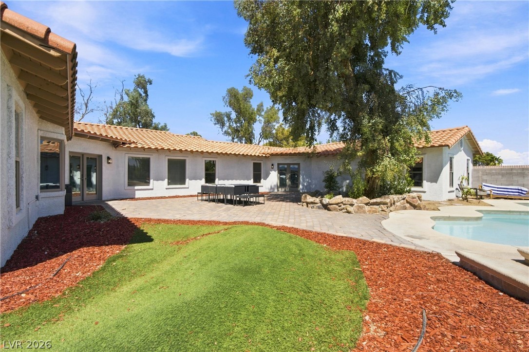 7744 Rancho Destino Road Las Vegas, NV 89123 - Photo 20 of 48 Spanish tile roofing and a paved patio area surround the backyard pool.