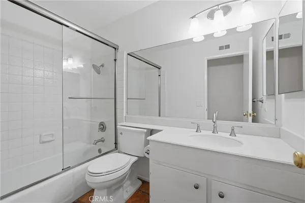a bathroom with a sink toilet vanity and shower