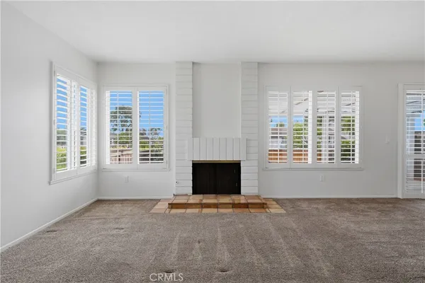 a living room with a fireplace and windows
