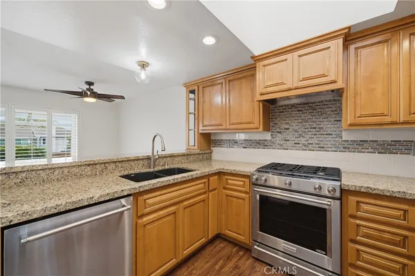 a kitchen with stainless steel appliances granite countertop a sink stove and cabinets