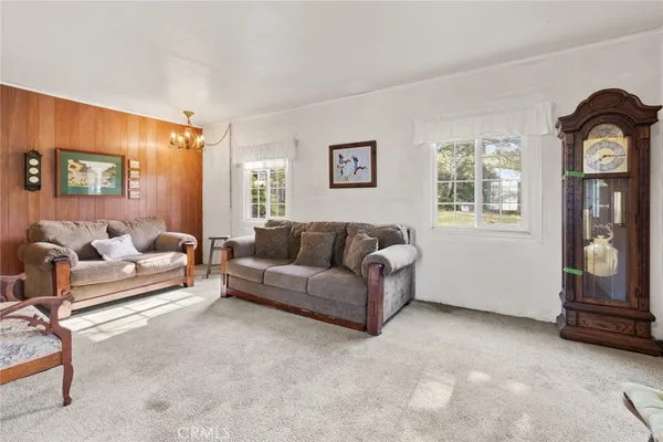 a dining room with wooden floor a chandelier a wooden table and chairs