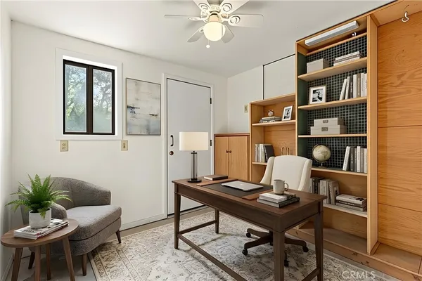 a living room with furniture a clock on wall and a window