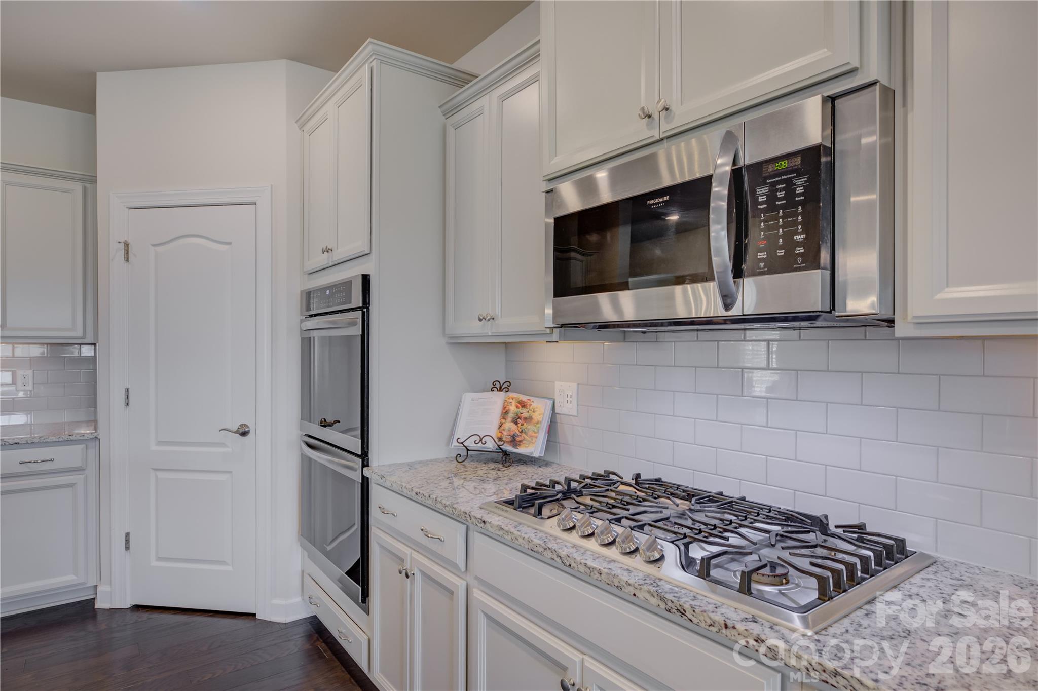 16541 Cozy Cove Road Charlotte, NC 28278 - Photo 12 of 47 a kitchen with stainless steel appliances granite countertop white cabinets a stove a microwave and a refrigerator