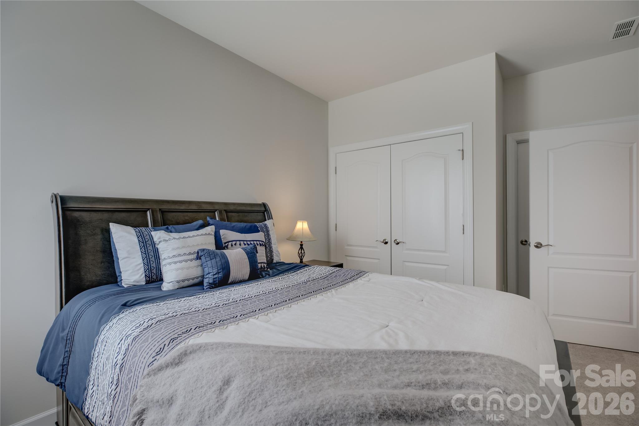 16541 Cozy Cove Road Charlotte, NC 28278 - Photo 29 of 47 a bedroom with a large bed and a mirror