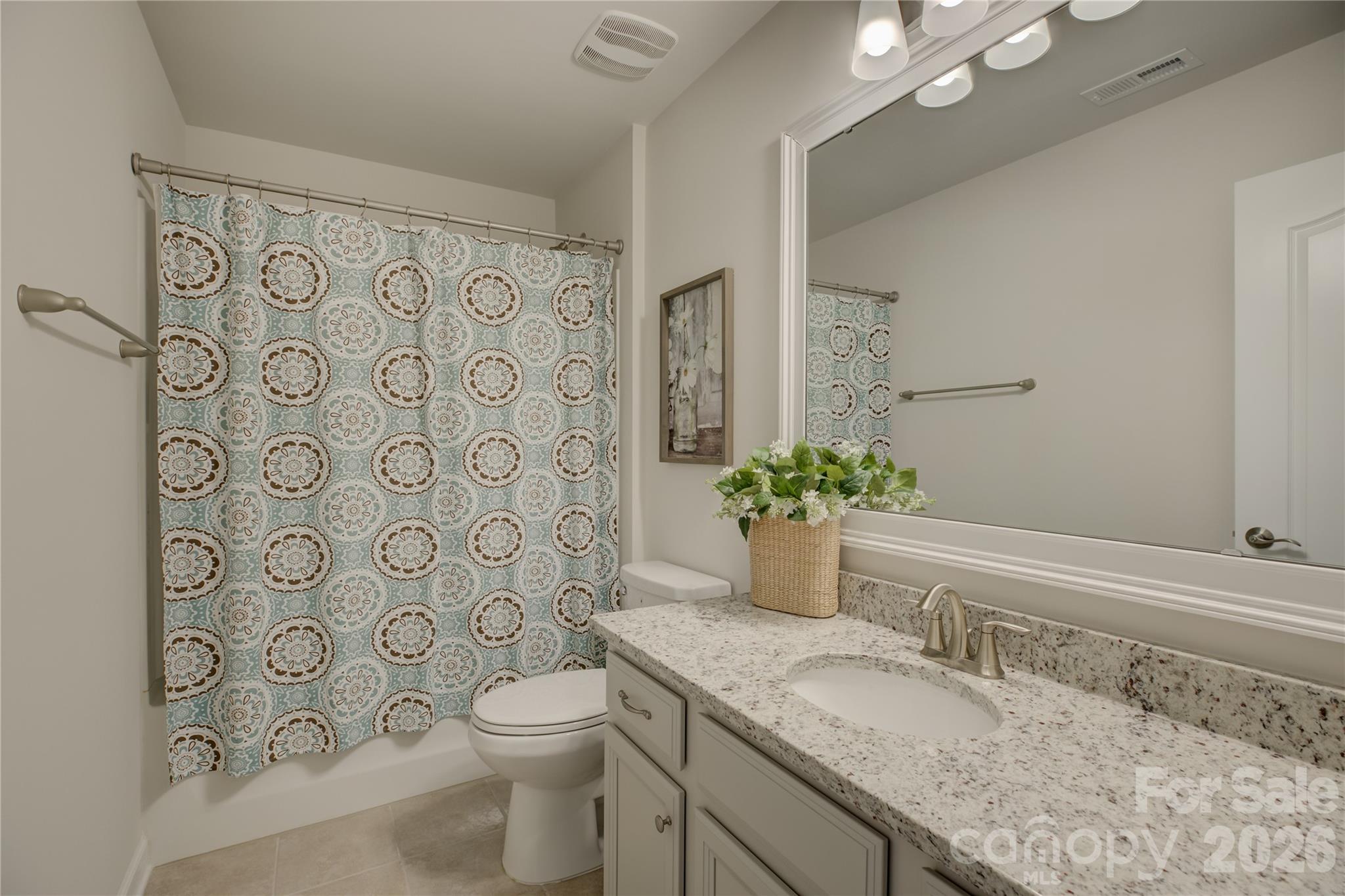 16541 Cozy Cove Road Charlotte, NC 28278 - Photo 36 of 47 a bathroom with a granite countertop toilet a sink a mirror a shower curtain