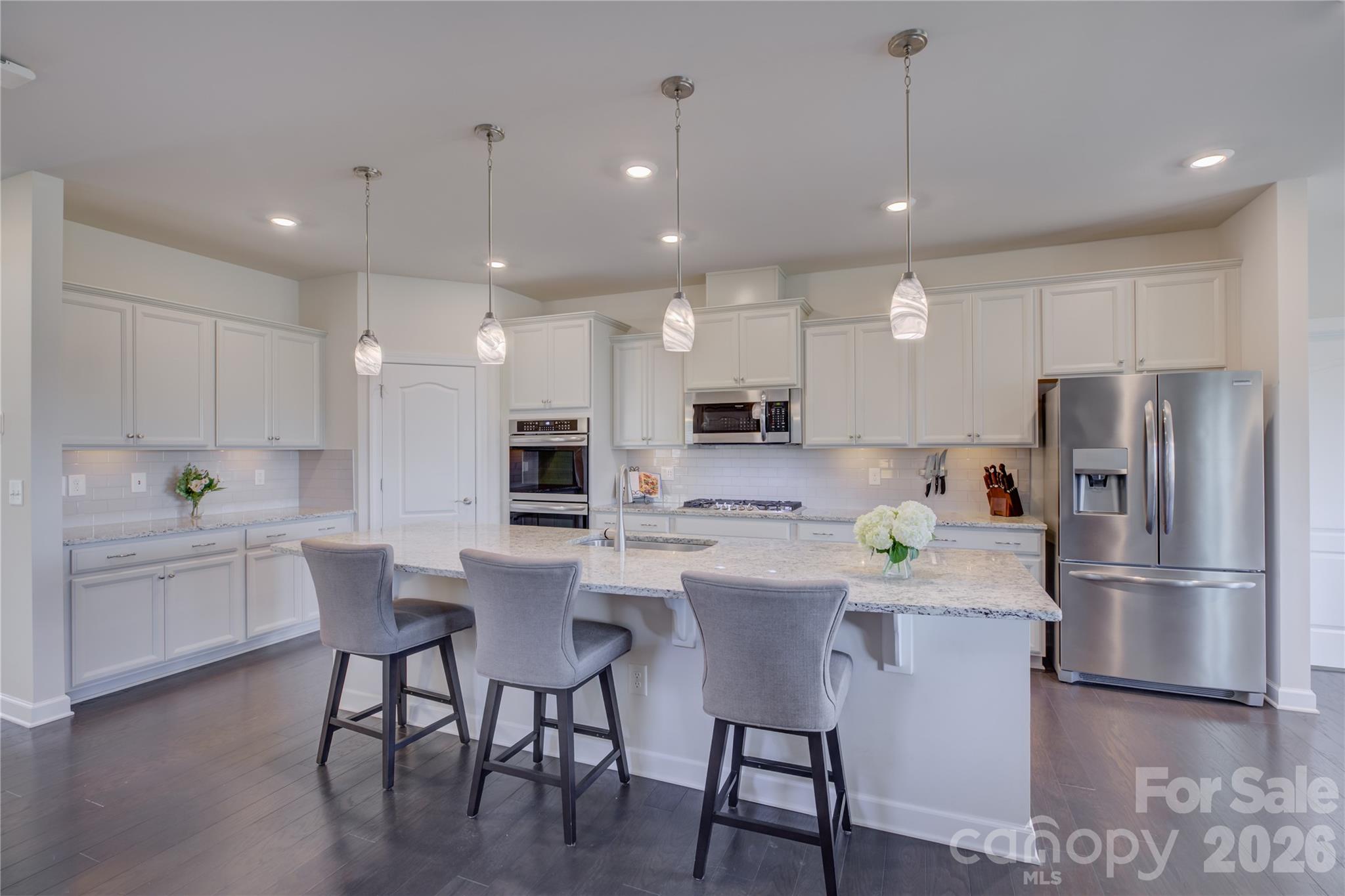 16541 Cozy Cove Road Charlotte, NC 28278 - Photo 10 of 47 a kitchen with a dining table chairs refrigerator and cabinets