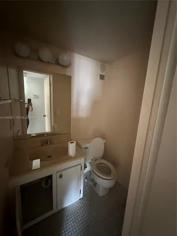 a bathroom with a granite countertop toilet sink and mirror