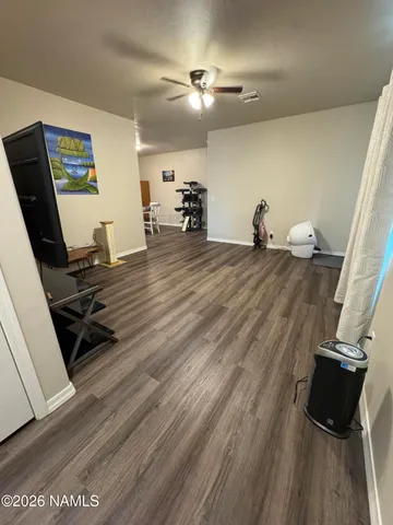 a room with gym equipment and wooden floor