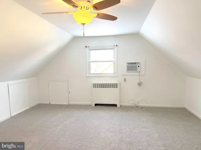 an empty room with a window and a chandelier fan