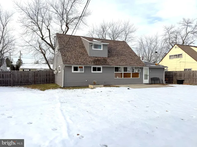 a front view of a house with a yard covered in snow