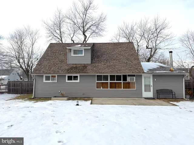 a front view of a house with a yard covered in snow