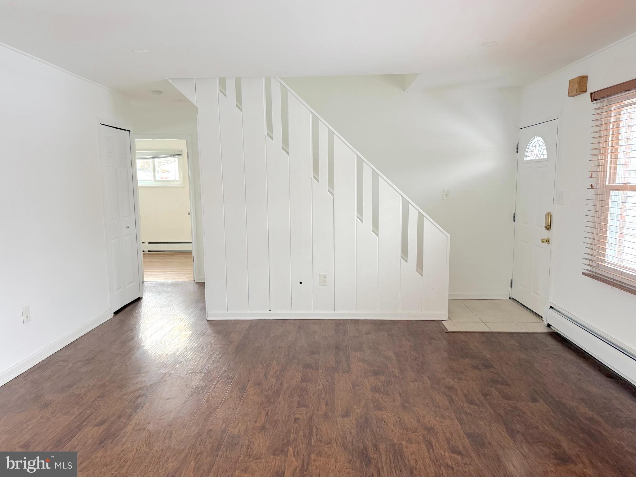 56 Indian Red Road Levittown, PA 19057 - Photo 2 of 19 a view of an empty room with wooden floor and a window