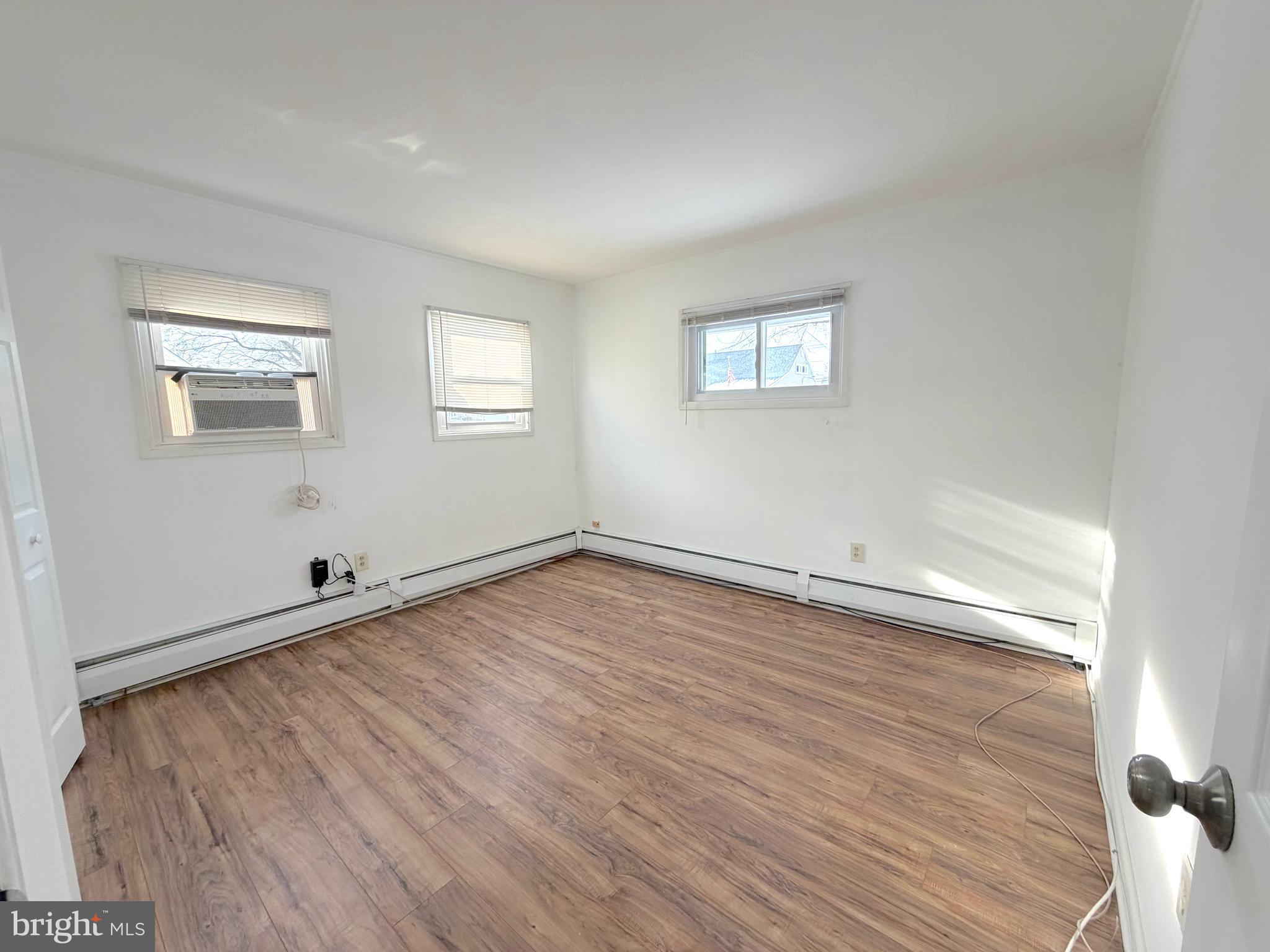 56 Indian Red Road Levittown, PA 19057 - Photo 6 of 19 an empty room with wooden floor and windows
