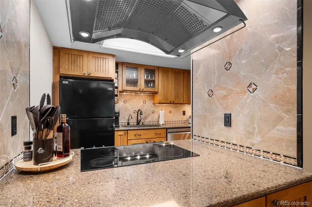 a kitchen with stainless steel appliances granite countertop a refrigerator and a sink