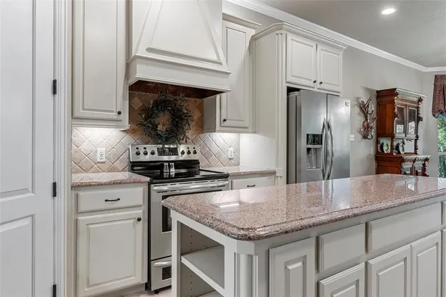 a kitchen with granite countertop stainless steel appliances and white cabinets