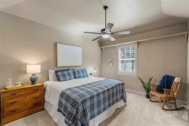 a spacious bedroom with a bed and a chandelier