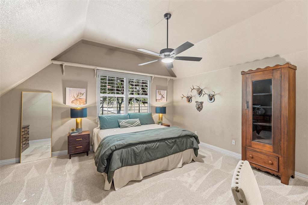 338 Estes Rch Road Bruceville, TX 76630 - Photo 33 of 40 a bedroom with a large bed and a chandelier