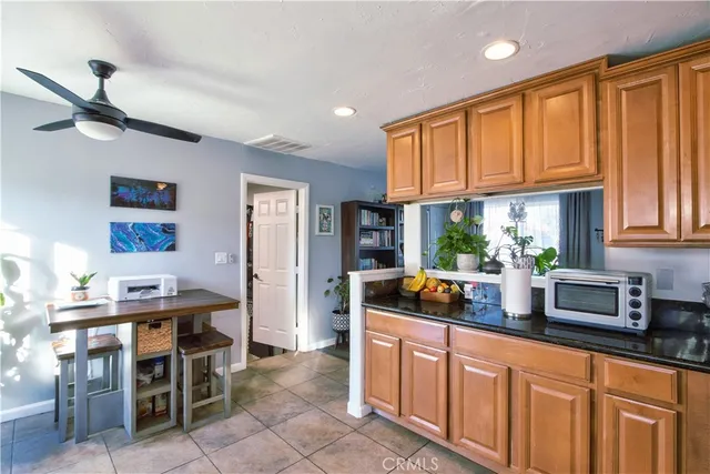 a kitchen with stainless steel appliances kitchen island granite countertop a table chairs in it and wooden floors
