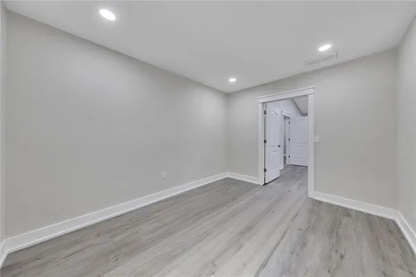 a view of an empty room with wooden floor