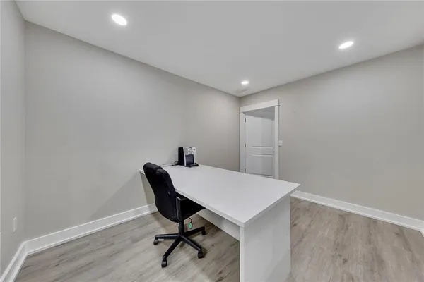 a view of a workspace with furniture and wooden floor