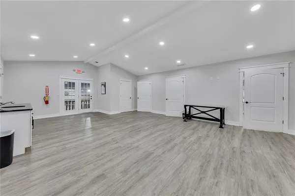 a view of an empty room with wooden floor and a fireplace