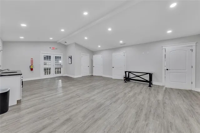 a view of an empty room with wooden floor and a fireplace