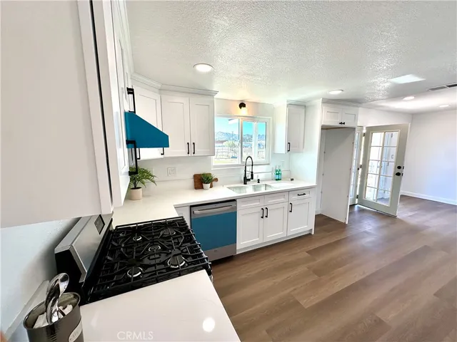 a kitchen with a sink a stove a refrigerator and cabinets