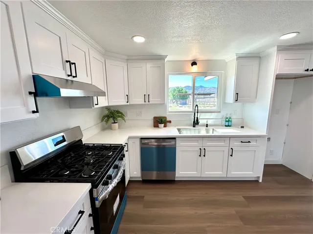 a kitchen with stainless steel appliances a white stove top oven sink and cabinets