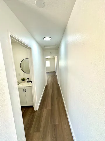 a view of a hallway with wooden floor