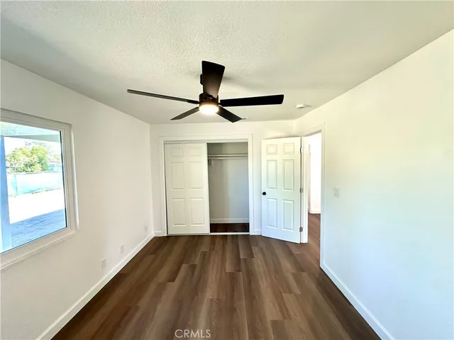 a view of a room with wooden floor and a ceiling fan