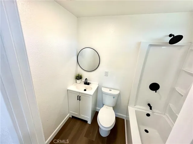 a bathroom with a toilet sink a mirror and shower