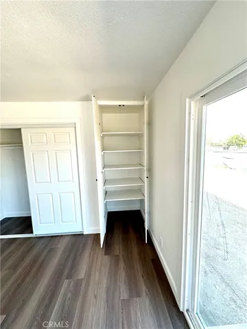 a view of walk in closet with wooden floor