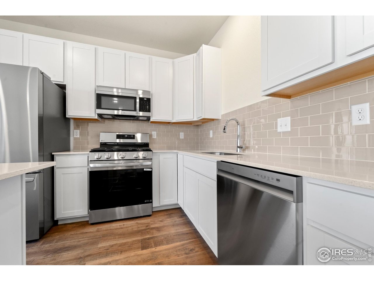 3829 Rhoadarmer Way Evans, CO 80620 - Photo 2 of 14 a kitchen with stainless steel appliances granite countertop a refrigerator stove microwave and sink