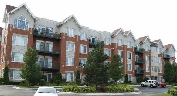 640 McHenry Road, Unit 2208 Wheeling, IL 60090 - Photo 1 of 17 a front view of a residential apartment building with a yard