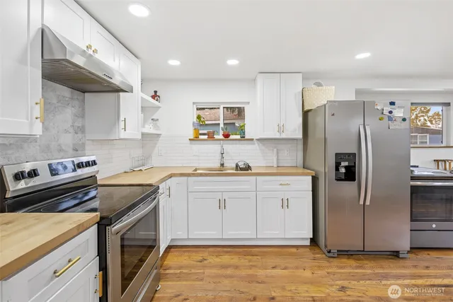 a kitchen with a refrigerator sink and cabinets