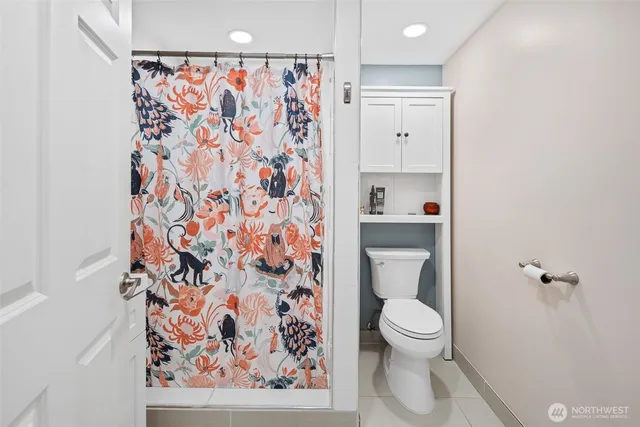 a bathroom with a toilet and a shower curtain