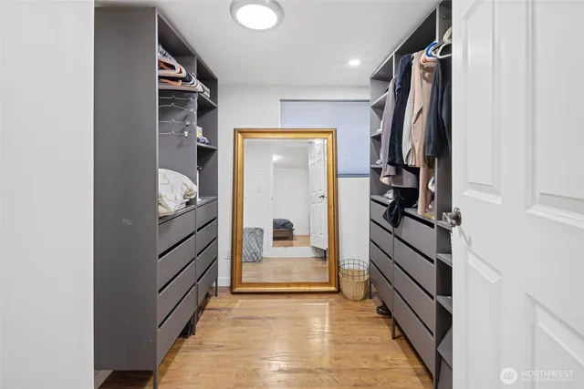 a view of walk in closet with clothes and shoes