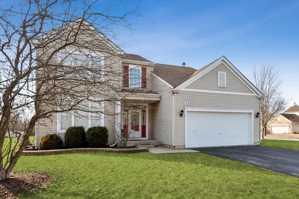 a front view of a house with a yard and garage