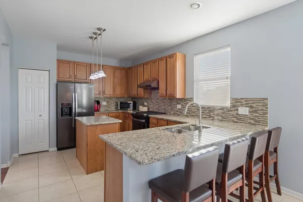 a kitchen with granite countertop a center island and a refrigerator
