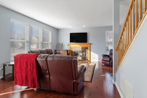 a living room with furniture a flat screen tv and a refrigerator