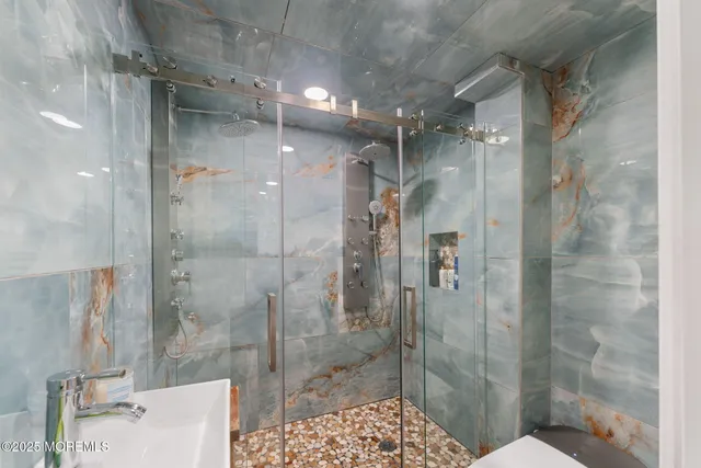 a bathroom with a granite countertop sink a toilet a mirror and shower