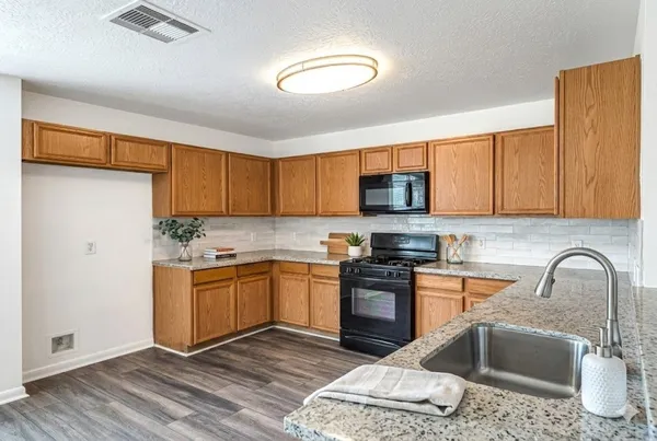 a kitchen with stainless steel appliances granite countertop a stove top oven a sink dishwasher and a microwave oven on the blue kitchen countertops